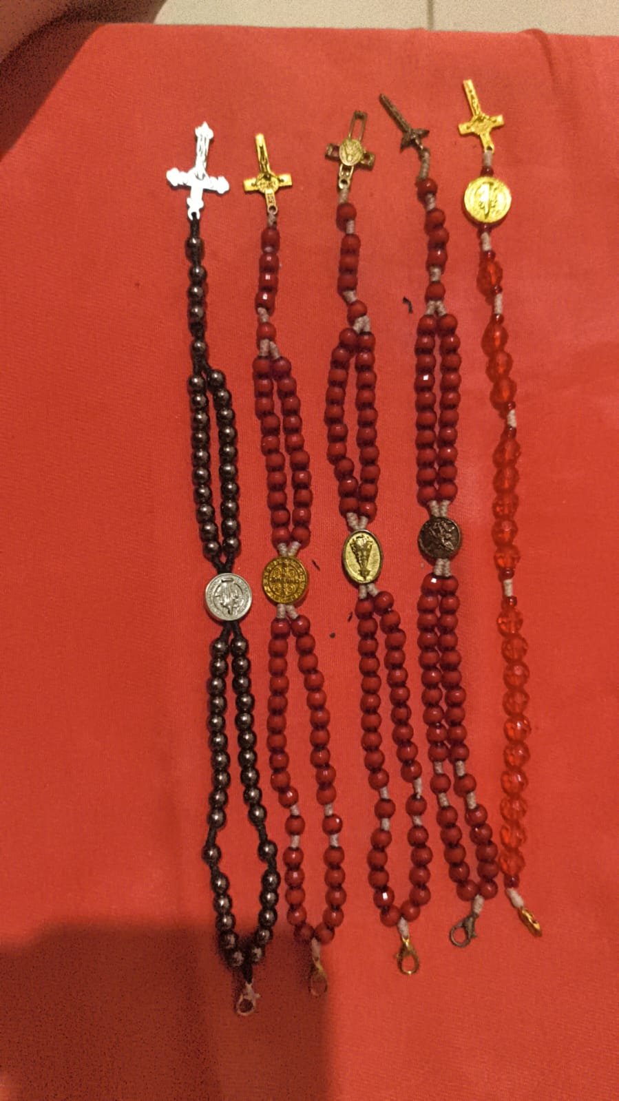 Peças religiosas artesanais montadas em contas vermelhas